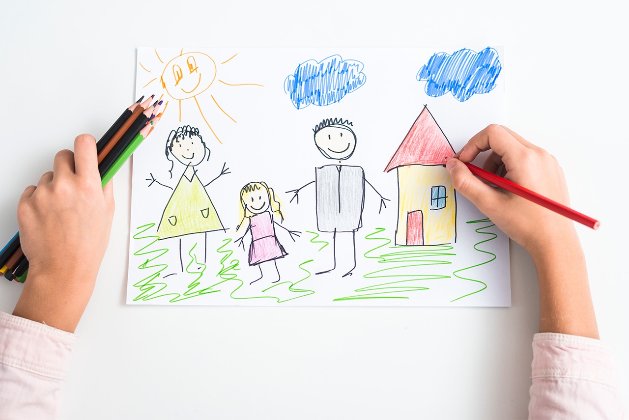 Mão de criança desenhando família e casa em uma folha de papel